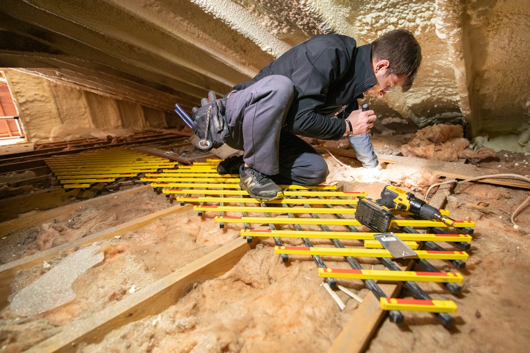 Technicien réalisant des travaux d'isolation de combles, dispositif isolation à 1 euro 2026 Technicien réalisant des travaux d'isolation de combles, dispositif isolation à 1 euro 2026